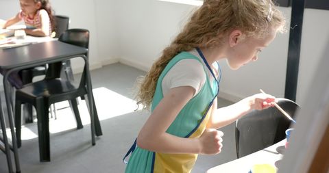Child Painting with Watercolors in Classroom, Focusing on Art Project - Download Free Stock Images Pikwizard.com