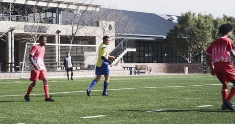 Youth soccer players practicing on field near school