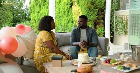 Couple Celebrating Birthday with Cake and Gifts Outdoors