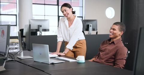 Colleagues High-Fiving in Modern Office for Team Success