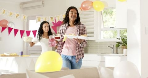 Friends Preparing for Birthday Party in Bright Kitchen with Decorations