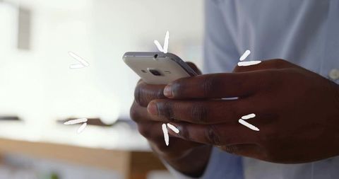 Close-Up of Hand Holding Smartphone in Home Office Environment