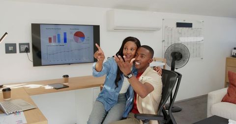 Couple collaborating and analyzing financial charts on laptop