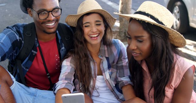 Multicultural friends smiling while viewing smartphone outdoors - Download Free Stock Images Pikwizard.com