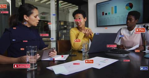 Diverse team collaborating over sales dashboard with social media overlays in boardroom