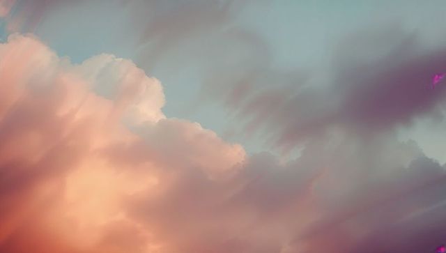 Pastel dawn skyscape with cumulus clouds in soft hues