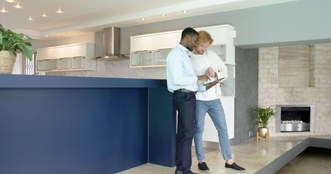 Diverse couple with estate agent reviewing home on tablet