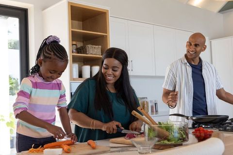 African american family cooking nutritious meal together in sunlit modern kitchen