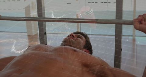 Athlete bench pressing in gym with modern architecture