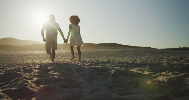 Young couple enjoys a romantic walk on the beach at sunset - Download Free Stock Photos Pikwizard.com