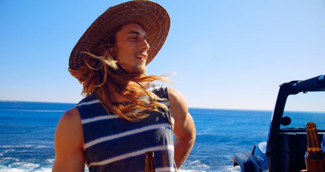 Young Man Enjoying Beach Vacation with Beer Bottle on Sunny Day - Download Free Stock Images Pikwizard.com