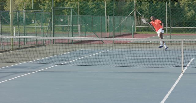 Man playing tennis on outdoor court hitting serve - Download Free Stock Images Pikwizard.com