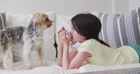 Girl Relaxing on Sofa with Dog During Indoor Covid Quarantine