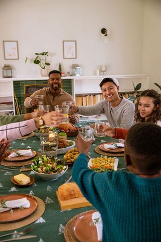 Diverse Friends Celebrating with Toast at Holiday Dinner Table