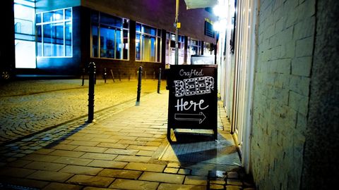 City Night with Bar Sign on Cobblestone Street
