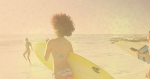 Surfers Heading to Ocean Holding Vibrant Surfboards on Sandy Beach