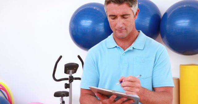 Personal Trainer Writing Notes in Fitness Center - Download Free Stock Images Pikwizard.com