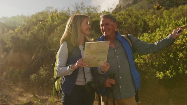 Senior Caucasian couple hiking through forest using map and compass, enjoying nature and each other's company. Suitable for themes of travel, adventure, outdoor activities, senior lifestyle, nature exploration. Useful for promoting hiking gear, travel destinations, retirement activities.