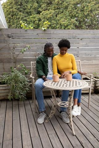 Romantic Couple Relaxing Outdoors with Coffee on Patio