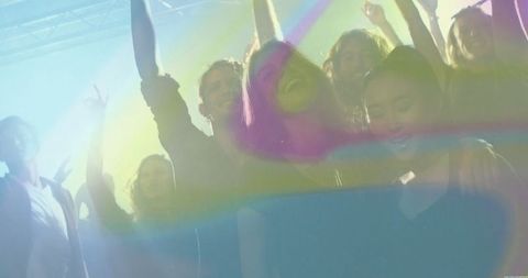 Young Friends Dancing in Club with Vibrant Lights and Haze