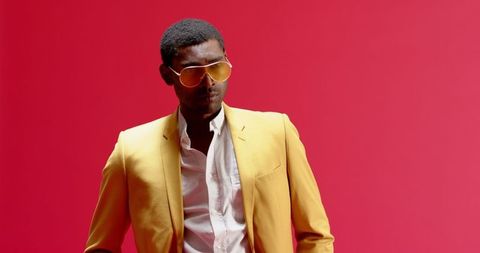 Confident Man in Yellow Blazer with Red Background
