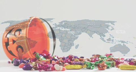 Spilling halloween candy from jack-o'-lantern bucket with world map overlay