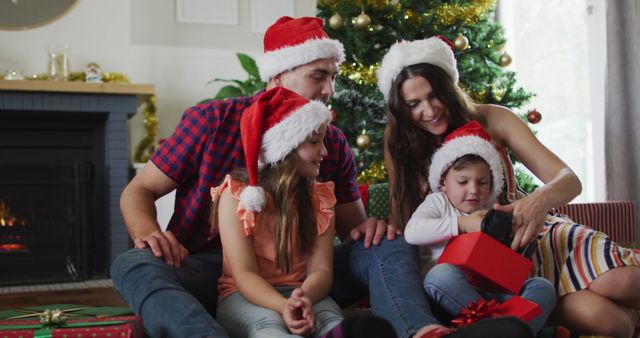 Family Opening Christmas Presents Together by Fireplace - Download Free Stock Images Pikwizard.com