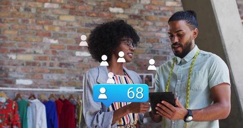 Boutique retail team collaborating over tablet reviewing social follower alert 68