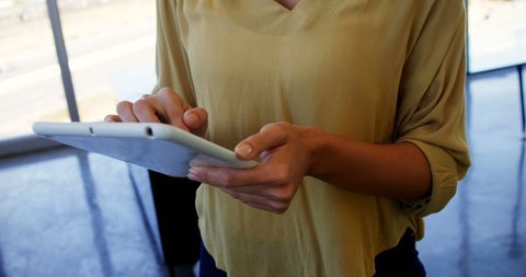 Young adult using tablet in modern workspace