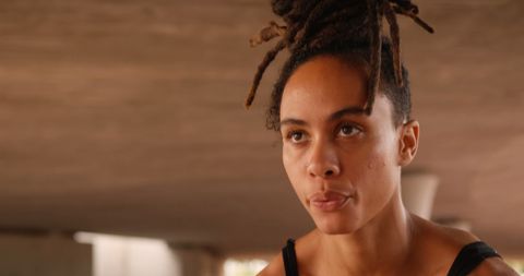 Focused African American Woman with Dreadlocks in Urban Environment