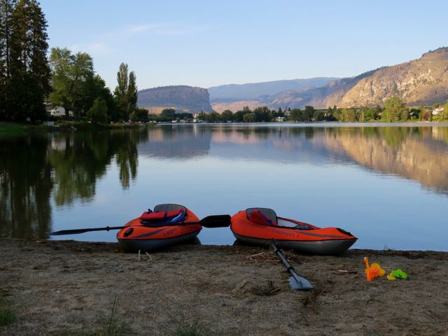 Two Red Kayaks on Tranquil Lake Shoreline with Scenic Mountain View - Download Free Stock Photos Pikwizard.com