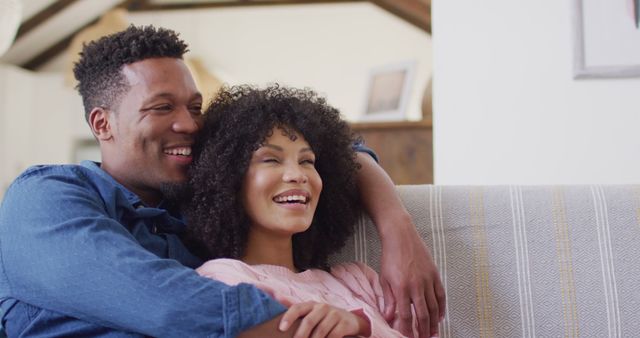Happy african american couple embracing together in living room. Spending quality time at home together concept.