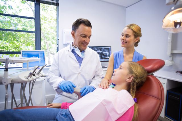 Dentist engaging with young patient in modern dental clinic. Ideal for use in healthcare promotions, dental care advertisements, pediatric dentistry brochures, and educational materials about oral health.