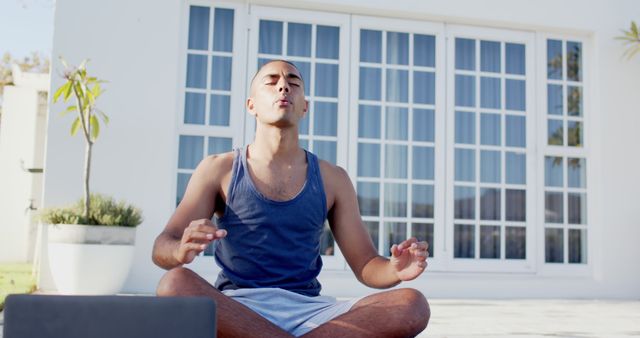 Young Man Meditating Outdoors in Front of House with White Windows - Download Free Stock Images Pikwizard.com