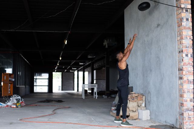 African american man exercising with a medicine ball in empty building. urban fitness healthy lifetyle.