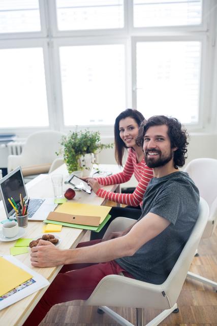 Male and female graphic designers working together in office