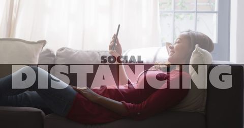 Woman Relaxing at Home on Couch Using Smartphone
