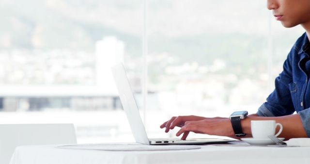 Person Working on Laptop in Bright Office with City View - Download Free Stock Images Pikwizard.com