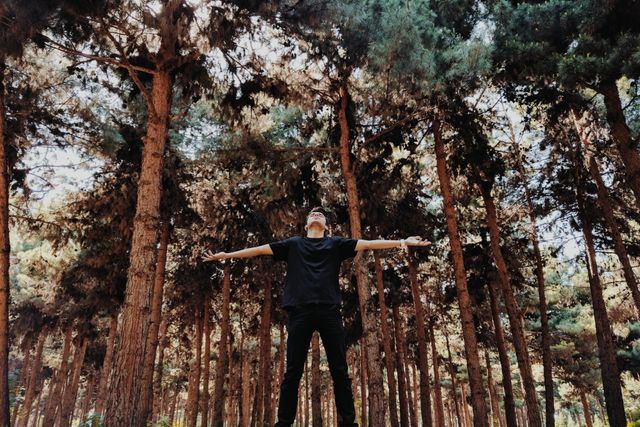 Young Man Embracing Nature in Forest with Arms Outstretched - Download Free Stock Photos Pikwizard.com