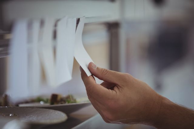 Close-up of chef holding an order list in the commercial kitchen at restaurant