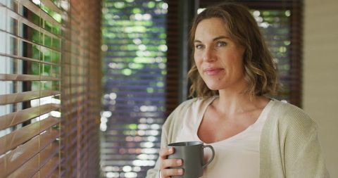Pregnant woman enjoying tea by window