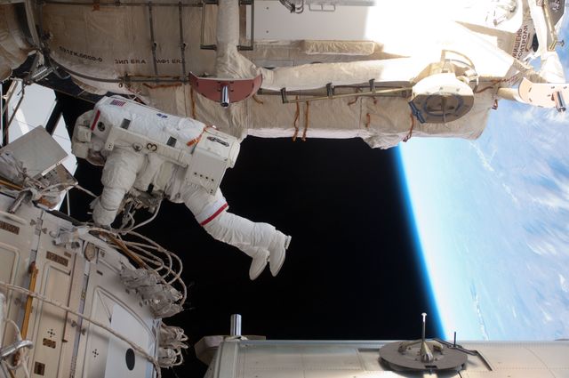 An astronaut is depicted floating outside the International Space Station during a spacewalk. The vastness of outer space and a partial view of Earth provide a stunning backdrop. This image can be used to illustrate the complexities of space exploration, the daily activities of astronauts, or the engineering marvels of working in space. Suitable for educational materials, science articles, and presentations on space missions.