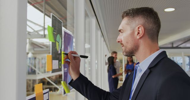 Man Planning Marketing Strategy on Office Wall with Sticky Notes - Download Free Stock Images Pikwizard.com