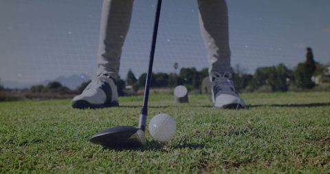 Golfer Preparing to Drive Ball on Green Turf