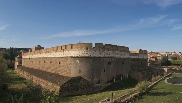 Fortified citadel rising on hill with bastions, crenellations and dry moat