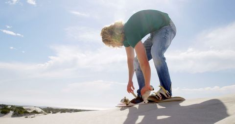 Young Man Sandboarding on Sunny Dune Adventure