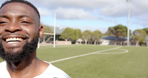 Smiling Athlete on Empty Residential Soccer Field on Sunny Day