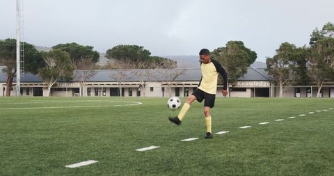 Soccer Player Practicing Alone on School Field Focused on Skills