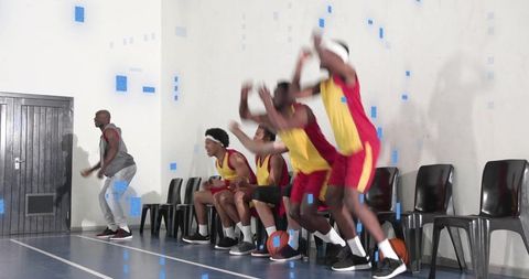 Basketball bench erupting with players jumping, celebrating while coach directing sideline