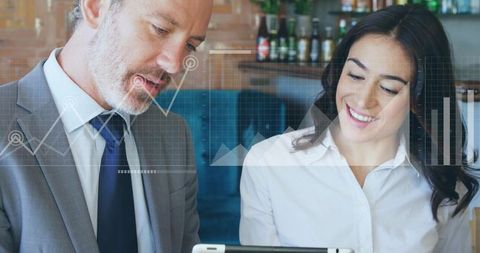 Executive and colleague reviewing tablet analytics in cafe with transparent data overlay